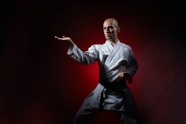 Genç sporcu elleri kırmızı bir arka planda blok yapıyor.