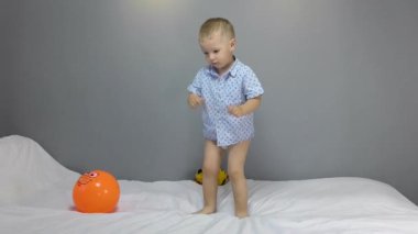 Turuncu toplu çocuk gri arka planda oynuyor.