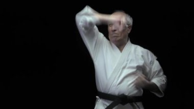 Yaşlı sporcu, elleri siyah arka planda olan blokları eğitir.