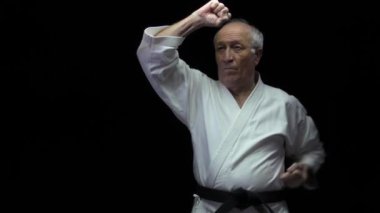 Yaşlı atlet elleri siyah bir arka planda blokları eğitir.