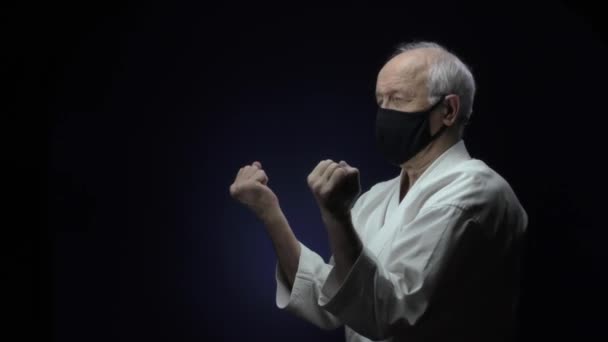 Black Medical Mask Old Athlete Beats Punches Dark Blue Background — Stock Video