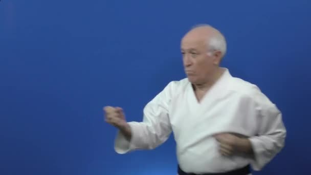 Fundo Azul Karategi Velho Atleta Está Treinando Blocos Socos — Vídeo de Stock