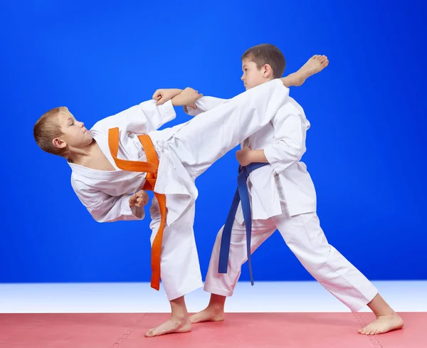 Jongens Trainen Slagen Arm Been Een Blauwe Achtergrond Stockfoto