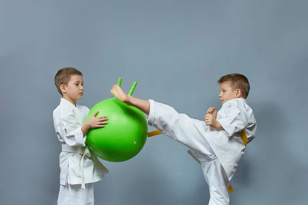 Beyaz Karategi Giyen Küçük Atlet Yeşil Topa Vuruyor — Stok fotoğraf