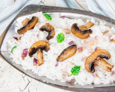 Metal uzun plaka üzerinde petrol mantarlı risotto.