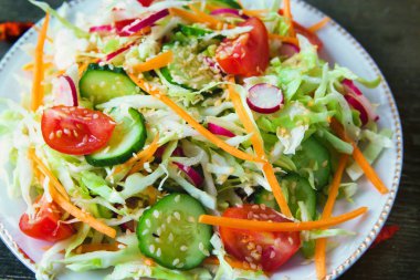 Taze Diyet salata, salatalık, domates, lahana, turp, havuç susam, zeytinyağı, sarımsak ve otlar ile. Sağlıklı yemek. Detoks ve vejetaryen kavramı.