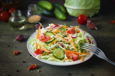 Taze Diyet salata, salatalık, domates, lahana, turp, havuç susam, zeytinyağı, sarımsak ve otlar ile. Sağlıklı yemek. Detoks ve vejetaryen kavramı.