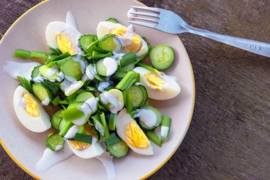 Tavuk yumurta, yeşil soğan, salatalık ve yoğurt, bir plaka üzerinde taze sebze salatası diyet salata vejetaryen. Sağlıklı gıda. Sebze salatası.