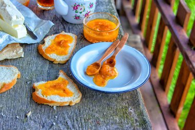 Lezzetli kahvaltı. Kayısı reçel, reçel, tereyağı, bir fincan çay ile ekmek erken kahvaltı için dilimlenmiş