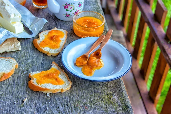 Lezzetli kahvaltı. Kayısı reçel, reçel, tereyağı, bir fincan çay ile ekmek erken kahvaltı için dilimlenmiş