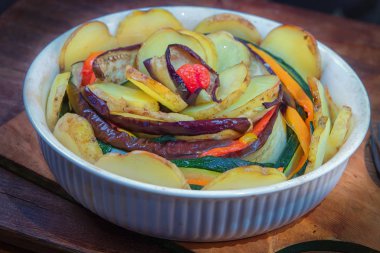 Kırmızı biber, patlıcan, soğan, domates, Genç patates ve kabak beyaz seramik şeklinde pişmiş spiral.