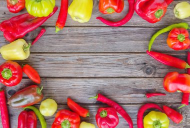 Üstten görünüm eski rustik arka plan üzerinde renkli taze organik biber. Yukarı alay.