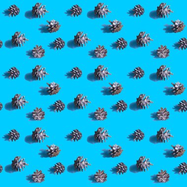 Köknar koniler canlı mavi arka plan ile sorunsuz arka plan. Sert gölgeler. Noel sanat arka plan. En az yazdırma kavramı. Düz yatıyordu.