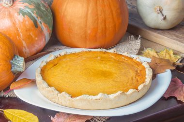 Geleneksel Amerikan taze parlak turuncu ev yapımı pasta pişirme çanağı ahşap masa üzerinde kabak ile yuvarlak. Şükran günü için yemek.