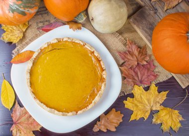Geleneksel Amerikan taze parlak turuncu ev yapımı pasta pişirme çanağı ahşap masa üzerinde kabak ile yuvarlak. Şükran günü için yemek.