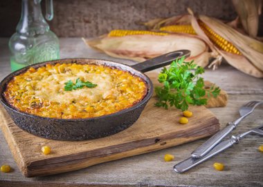 Traditional corn casserole with cheese. Below the corn - parsley mix is ground cheese, olive, egg, baked onion, garlic. clipart