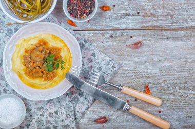 Havuç ve soğan ve patates püresi, garnitür ile kızarmış tavuk karaciğer ve maydanoz ile hizmet sarımsak okları Marine. T op görünümü.