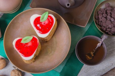 Lezzetli bir çilekli pasta ve küçük çikolata ile çay molası. Bir kompozisyon testi ile bakır ve kil levha. Arap kavramı.