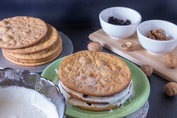 piece baked cakes for homemade honey cake are pouring white butter cream.