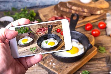 Adam iki küçük tavalar tohumlar, jambon, domates ve maydanoz ile ev yapımı ekmek ile resim kızarmış yumurta alır.