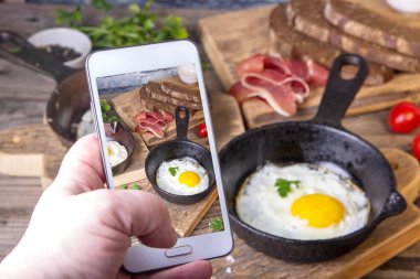 Adam iki küçük tavalar tohumlar, jambon, domates ve maydanoz ile ev yapımı ekmek ile resim kızarmış yumurta alır.