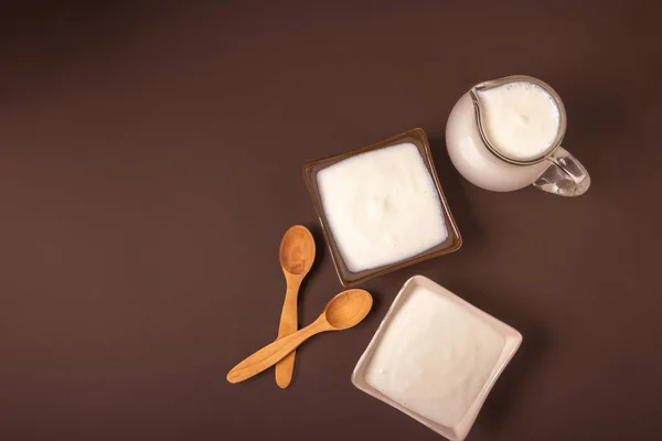 Seramik Meydanı'nda ev yapımı yoğurt kaseler, bir sürahi ağzına kadar dolu arkasında kase yoğurt. Sağlıklı gıda yoğurt konseptinden. Üstten Görünüm.