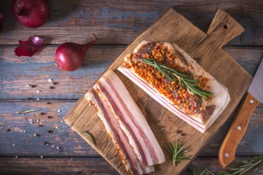 Koyu zeminde tuzlu pastırma parçaları. Baharatlar ile sağlıklı gıda, otlar vintage masada biberiye dekore edilmiştir. Yağ, domuz yağı, donyağı, yağ. Üstte görüntü
