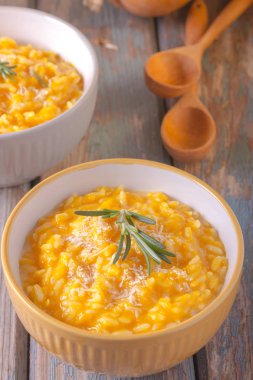 Ahşap arka plan üzerinde bir kase parmesan peyniri ile lezzetli kabak risotto. Rustik stil