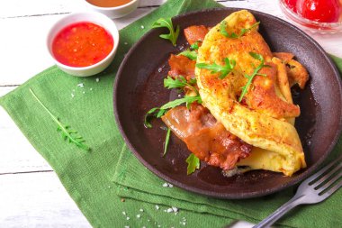 Arugula ve renkli salamura domates ile lezzetli pastırma omlet