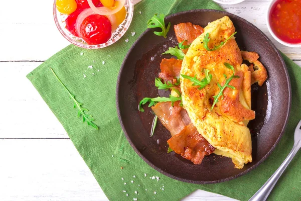 Délicieuse omelette au bacon avec roquette et tomates marinées colorées — Photo