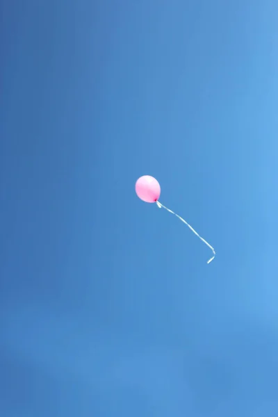 Mavi güneşli gökyüzüne karşı açık havada pembe zıplayan top