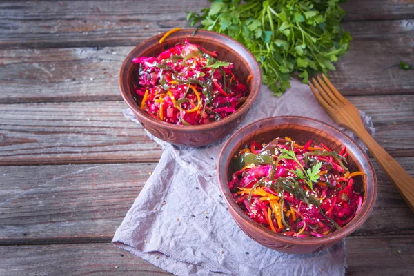 Deniz lahanası, havuç, pancar ve susam ile diyet salatası, ahşap arka plan üzerinde rustik seramik kase zeytinyağı serpilir. Detoks kavramı