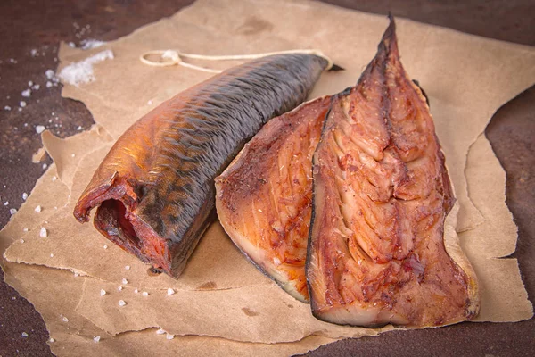 Filetes de cavala defumados em papel artesanal em uma mesa metálica enferrujada rústica. Vista superior — Fotografia de Stock