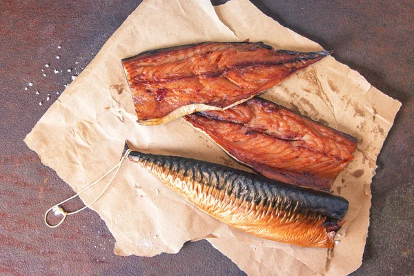 Filetes de caballa ahumados sobre papel artesanal sobre una mesa de metal oxidado rústico. Vista superior — Foto de Stock