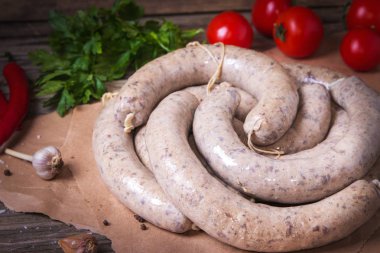 Sebzeli bir zanaat kağıt üzerinde çiğ taze beyaz sosis. Weisswurst bir yığın halinde. Dilimlenmiş dana eti ve domuz pastırması yapılan geleneksel Bavyera veya Münih beyaz sosis. Oktoberfest konsepti