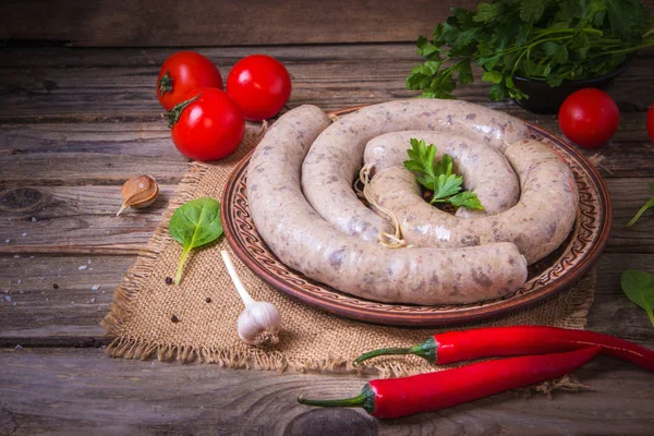 Sebzeli bir tabakta çiğ taze beyaz sosis. Weisswurst bir yığın halinde. Dilimlenmiş dana eti ve domuz pastırması yapılan geleneksel Bavyera veya Münih beyaz sosis. Oktoberfest konsepti