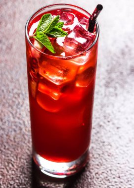 Buz küpleri ve nane yaprakları ile taze kırmızı kokteyl. Kırmızı yaz meyveleri veya nar. Lezzetli içecek