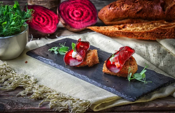 Tostadas con un círculo de remolachas, queso de cabra y un trozo de salmón . — Foto de Stock