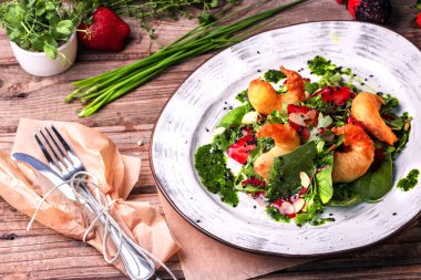 Izgara karidesleri, çilek, Arugula, maydanoz, ıspanak ve soğan ile lezzetli hafif salata, kızarmış susam ile serpilir ve yeşil ıspanak sos ile sezgiyle.