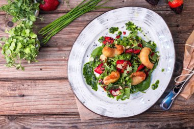 Izgara karidesleri, çilek, Arugula, maydanoz, ıspanak ve soğan ile lezzetli hafif salata, kızarmış susam ile serpilir ve yeşil ıspanak sos ile sezgiyle.