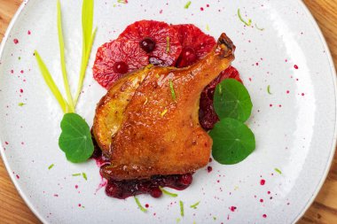 Kızılcık soslu kırmızı greyfurt üzerine fırında ördek bacağı. Lezzetli yemek..