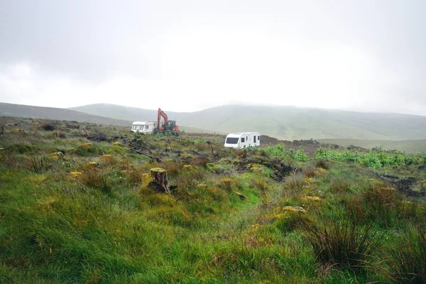 Caravanas de trabajadores forestales y excavadora en la niebla — Foto de Stock