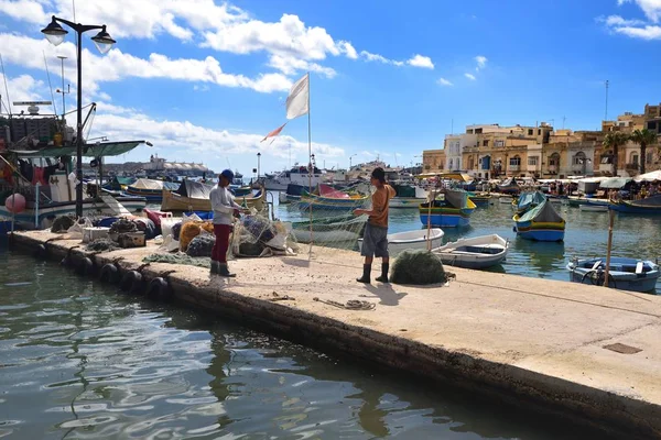 Het schoonmaken van de visnetten in de haven van Marsaxlokk — Stockfoto