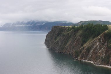 Yazın Baykal Gölü. Yağmurlu ve sisli havada Olkhon Adası manzarası. Göl doğal arka plan. Kopya alanı ile güzel manzara arkaplanı