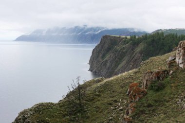 Yazın Baykal Gölü. Yağmurlu ve sisli havada Olkhon Adası manzarası. Göl doğal arka plan. Kopya alanı ile güzel manzara arkaplanı