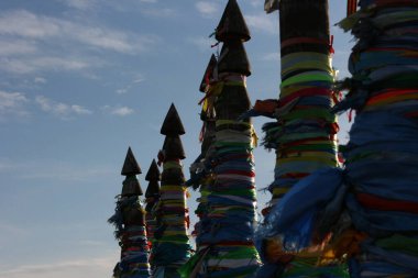  Olkhon / Rusya - 27 Haziran 2019: Şaman, Baykal Gölü 'nde gün batımı ışığıyla sallanıyor. Olkhon Adası 'nda bağlama direğinin demirleri kurdelelerle bağlanmış. Güzel yaz manzarası.