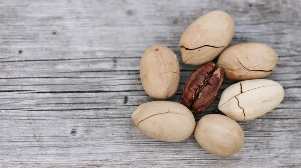 Pecan Nuts on wooden background, top view with copyspace. Close up veiw of nuts. Banner size with copy space.