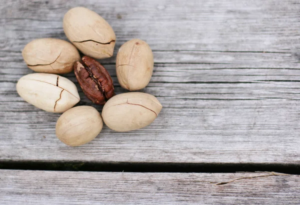 Pecan Nuts on wooden background, top view with copyspace. Close up veiw of nuts.