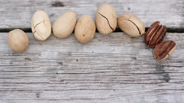 Pecan Nuts on wooden background, top view with copyspace. Close up veiw of nuts.