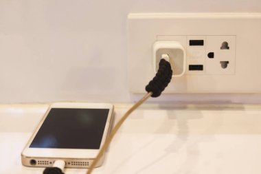 Electric socket with connected phone charger clipart